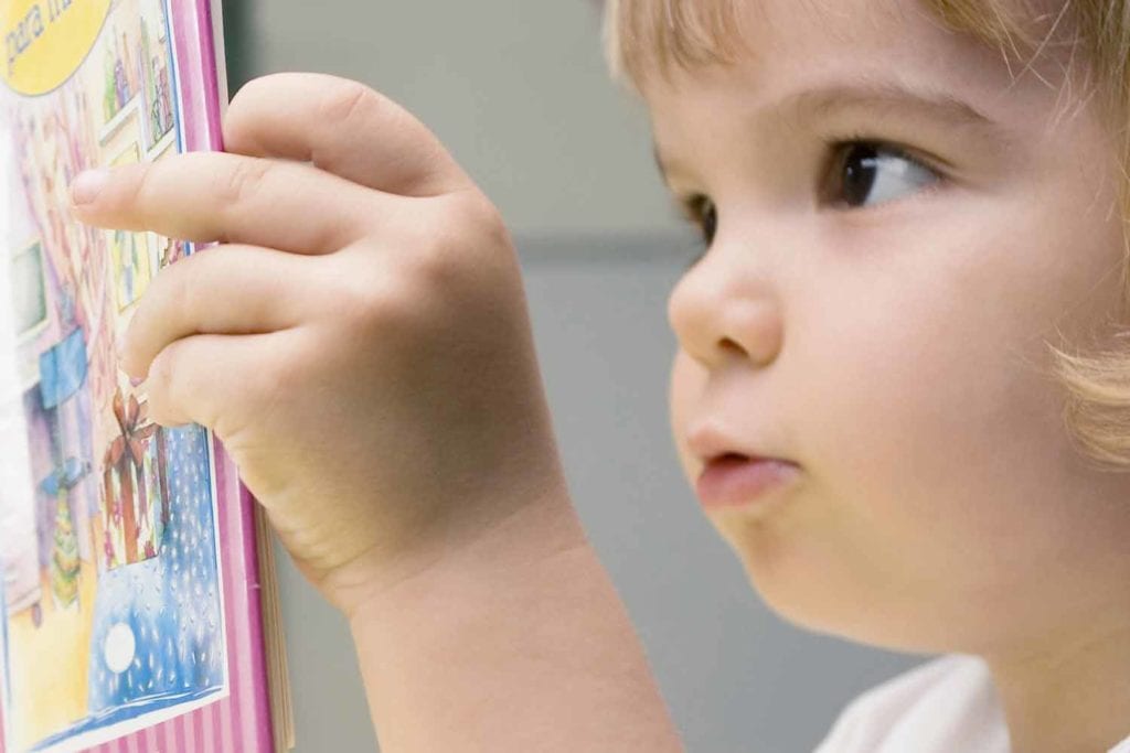 Toddler looking at book for language development